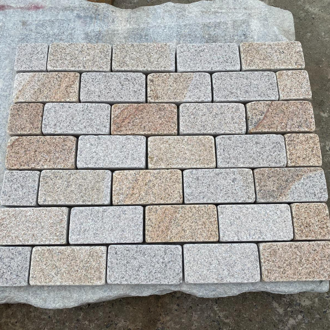 Paved area with stone tiles and a glass door in the background